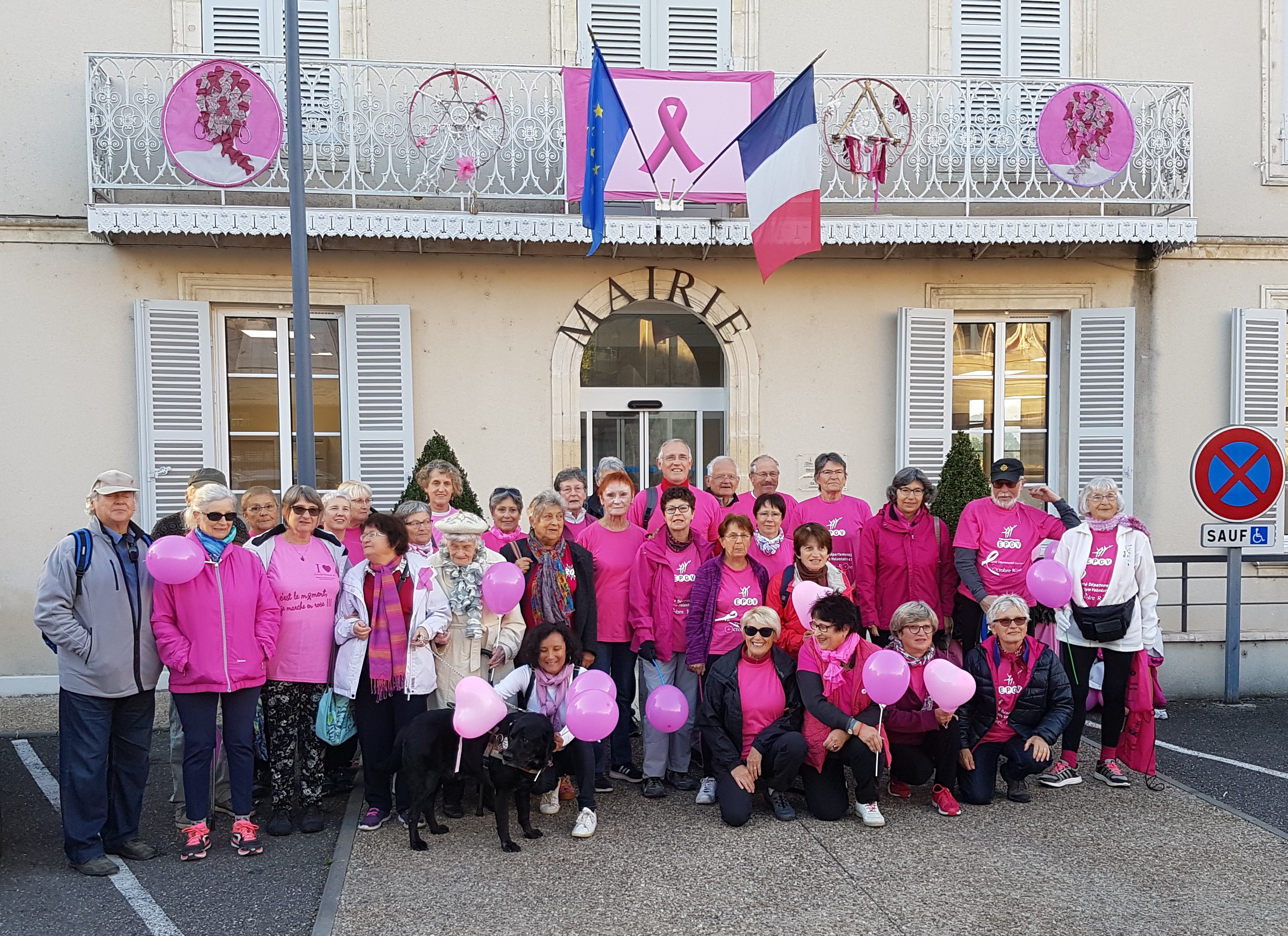 photo de groupe devant la mairie avec un tee-shirt rose